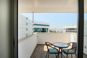 a balcony with a table and chairs and a window at Phaedrus Living: Luxury Suite Nicosia 505 in Nicosia