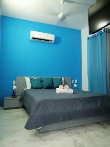 a blue bedroom with a bed with a blue wall at Casa merengue in Las Terrenas