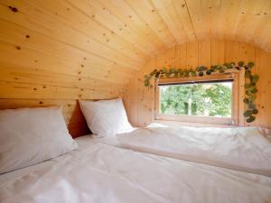 a room with two beds in a wooden room with a window at Haus Jagstblick in Kirchberg an der Jagst