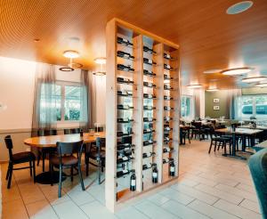 a dining room with tables and a wine cellar at Hotel Rössli Luterbach in Luterbach