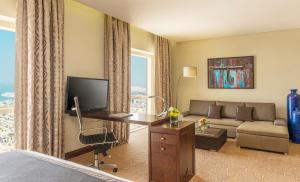 een hotelkamer met een bed, een bureau en een bank bij The Tower Plaza Hotel Dubai in Dubai