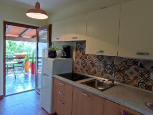 a kitchen with a sink and a refrigerator at Moratto's Apartments in Umag