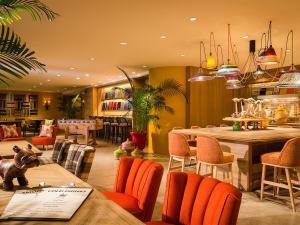 un ristorante con sedie arancioni e tavoli in una stanza di Hotel Francs a Chiba