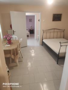 1 dormitorio con cama, mesa y comedor en Κεντρικό, άνετο και ζεστό διαμέρισμα, en Kamena Vourla