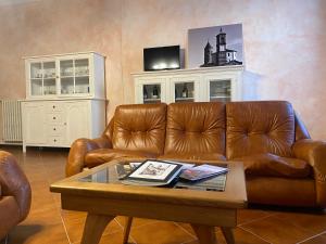 a living room with a brown leather couch and a coffee table at CASA DI NONNA RINDA-Via del Castello n6 in Monte Santa Maria Tiberina