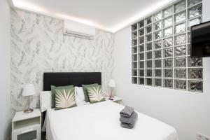 Noviciado Apartment في مدريد: غرفة نوم بسرير ابيض وتلفزيون