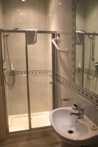 een badkamer met een glazen douche en een wastafel bij Devoncourt Short Term Rentals in Exmouth