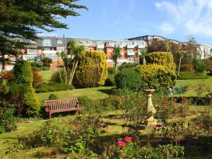 a park with a bench in the middle of a garden at Devoncourt Short Term Rentals in Exmouth