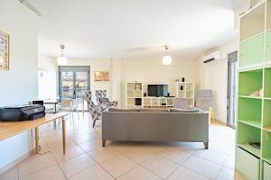 een woonkamer met een bank en een tafel bij Koukaki apartment 3 bedrooms 6 pers. in Athene