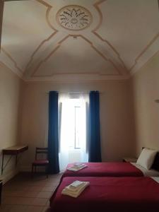 1 dormitorio con 1 cama y una ventana con cortinas azules en Residência D'Atalaia, en Fronteira