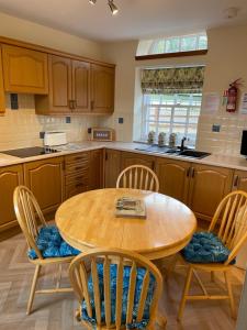 una cucina con tavolo e sedie in legno di The Towerview Coach Houses a Perth