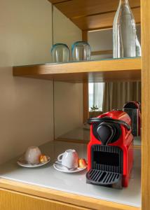 a red toaster sitting on a shelf with plates at Royal Azur Thalassa in Hammamet