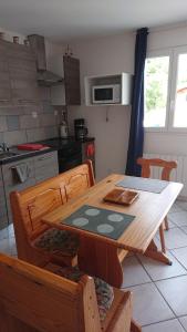 uma cozinha com uma mesa de madeira com cadeiras e uma sala de jantar em studio em Audenge