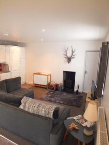 a living room with a couch and a fireplace at Boggle Dyke Cottage in Thornhill