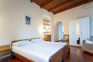 una camera con un grande letto bianco e un divano di Villa Magnolia Lago Maggiore a Besozzo