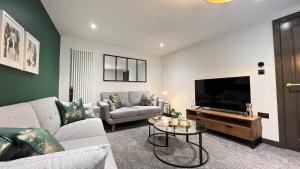 a living room with a couch and a flat screen tv at Canalside in Headingley