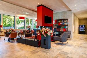 a lobby with a library with tables and chairs at Bastion Hotel Nijmegen in Nijmegen