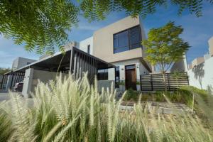 a house in the suburbs with tall grass at Villa Number 4 in Sharjah