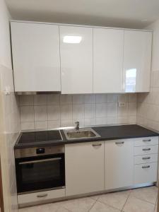 a kitchen with white cabinets and a sink at Lumbarda Apartment F2 in Lumbarda