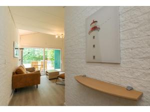 uma sala de estar com um sofá e um farol na parede em Holiday home near Lake Veere and Kortgene em Kortgene