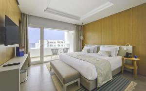 a hotel room with a large bed and a television at Royal Azur Thalassa in Hammamet