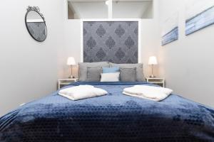 1 dormitorio con 1 cama azul y 2 almohadas en SISSI beautifully designed apatment close to main train station, en Viena