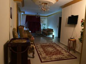 - un salon avec un canapé et un lustre dans l'établissement Asma Pyramids View, au Caire