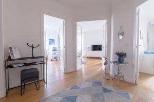 a living room with a chair and a mirror at Bel appartement bourgeois au centre-ville de Biarritz in Biarritz