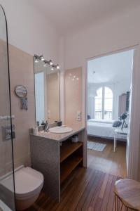 łazienka z umywalką, toaletą i lustrem w obiekcie Bel appartement bourgeois au centre-ville de Biarritz w Biarritz