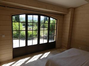 um quarto com uma grande janela numa casa em chic et champêtre em Solliès-Pont