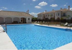 a large blue swimming pool in front of a house at Villa Fairways Golf By Mila Prieto in Arcos de la Frontera