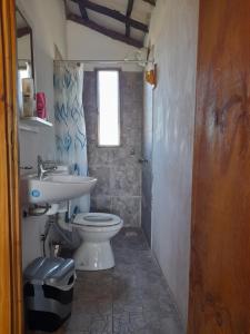 a bathroom with a toilet and a sink at Cabaña Pirayú in Oliveros +5 photos