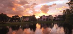 un tramonto su un lago di fronte alle case di My Home in Orlando a Kissimmee