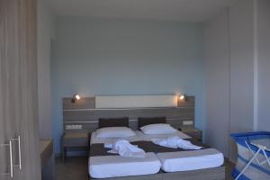 1 dormitorio con 2 camas y toallas blancas. en Thalassa House Apartments en Plakias