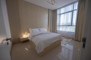 a bedroom with a white bed and a large window at Villa Number 4 in Sharjah