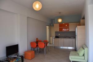 sala de estar con mesa y sillas y cocina en Thalassa House Apartments en Plakias