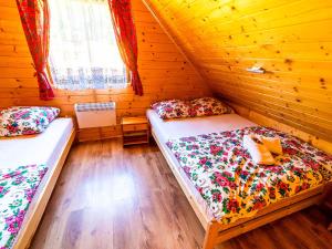 a bedroom with two beds in a wooden cabin at Domki pod Bieniatka w Szczyrku in Szczyrk