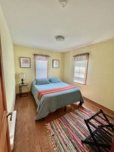 ein Schlafzimmer mit einem Bett und einem Teppich in der Unterkunft THE GREEN HOUSE - New River Gorge National Park in Lansing