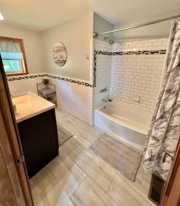 ein Badezimmer mit einer Badewanne, einem Waschbecken und einer Badewanne in der Unterkunft THE GREEN HOUSE - New River Gorge National Park in Lansing