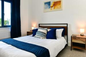 a bedroom with a large bed with blue pillows at Just Stay Wales - Heatherslade House, Southgate in Parkmill