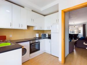 カレタ・デ・フステにあるModern 3 bedroom house with large pool and fast internet, 100ft from the sea - sleeps 6の白いキャビネットとコンロ付きオーブンを備えたキッチン