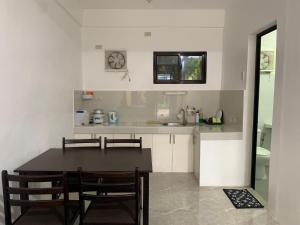 a kitchen with a table and chairs and a sink at Gil’s Inn Transient House in Sampalok