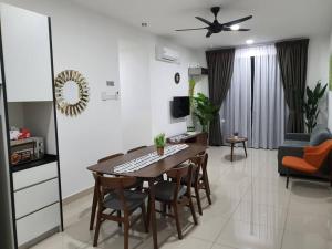 a kitchen and living room with a table and chairs at Pangsapuri Desaru Utama in Bandar Penawar