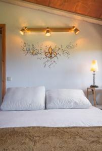 a bedroom with a white bed with flowers on the wall at Apartamento duplex rural con chimenea y vistas panorámicas desde la cama in San Martín Sacalm
