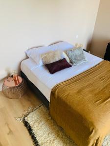 een bed met kussens in een slaapkamer bij appartement de charme, vue bassin, parking gratuit in Arcachon