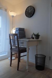 a desk with a chair and a clock on the wall at Ferienwohnung Holzmaden Am Platz in Holzmaden