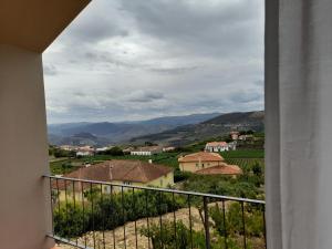 uma vista a partir de uma varanda de uma aldeia e montanhas em Quinta Manhas Douro em Provesende
