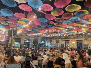 a crowd of people sitting at tables under umbrellas at Dimora delle Sciare - Centro Storico in Catania