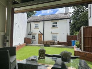 a patio with a table and a house at Old Smithy Cottage in Great Singleton