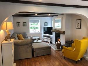 a living room with a couch and a fireplace at Old Smithy Cottage in Great Singleton